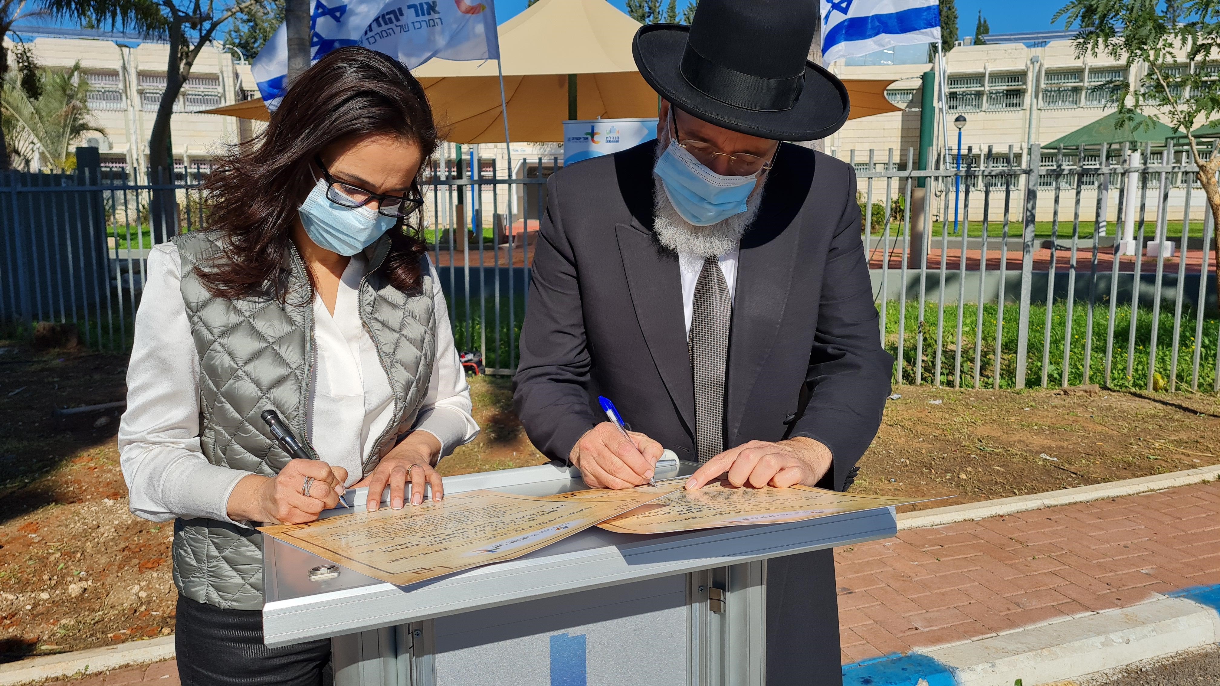 ליאת שוחט ורב העיר הרב ציון כהן חותמים על המגילות